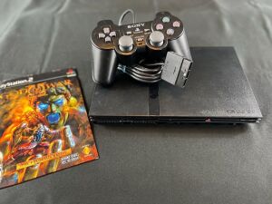 PlayStation 2 Model 2 Slim console with controller and God of War II Demo